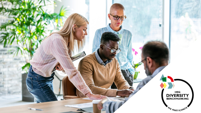 Diverse Gruppe von Personen diskutiert über Diversity Benchmarking in einem modernen Büro