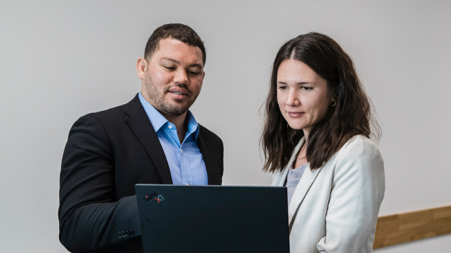 Zwei Personen analysieren Daten auf einem Laptop zur Mitarbeitendenzufriedenheit