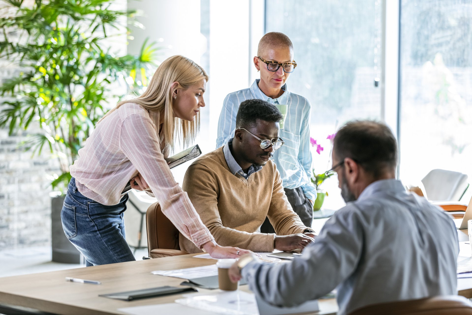 Diverse Gruppe von Personen diskutiert über Diversity Benchmarking in einem modernen Büro