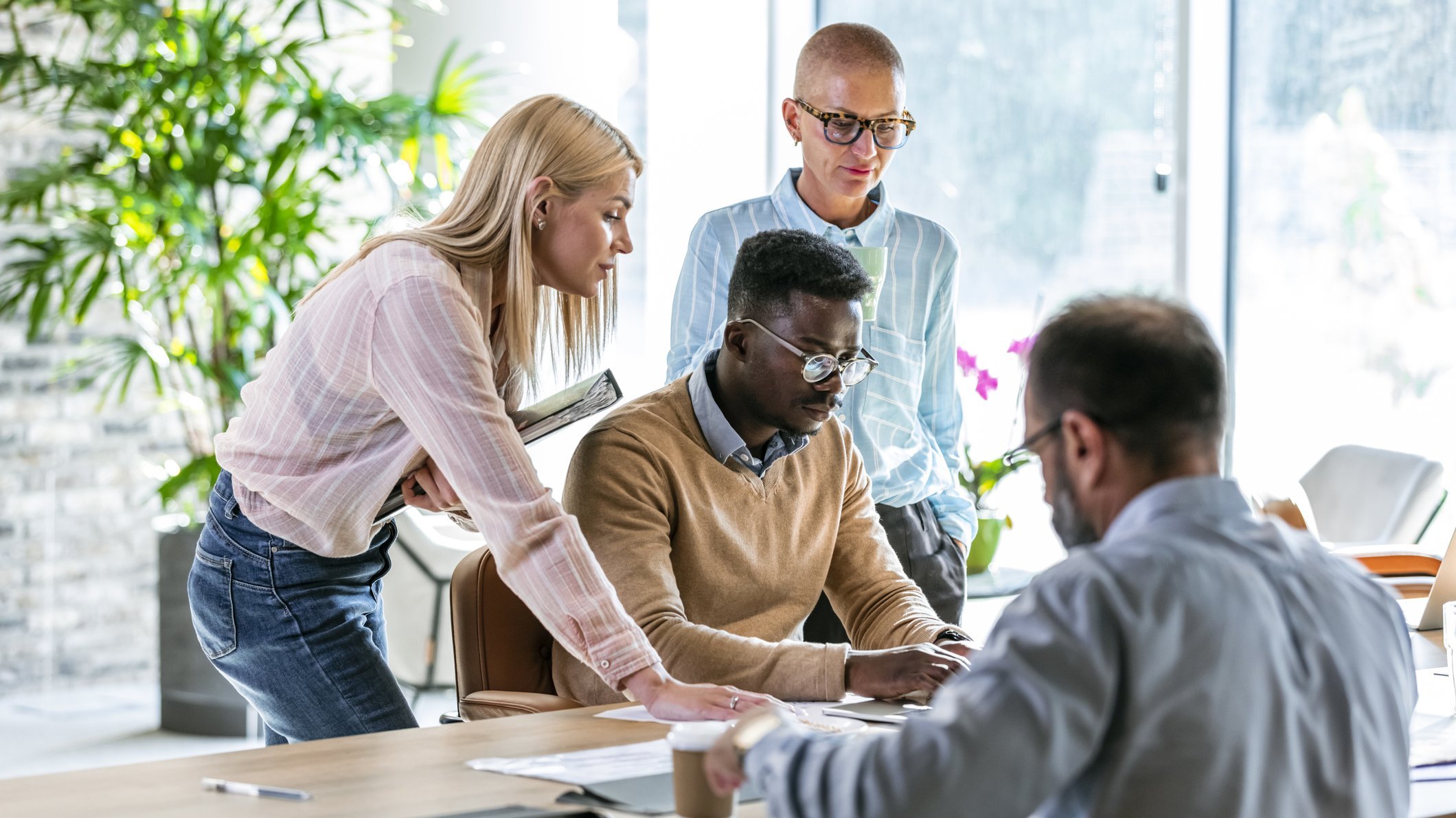 Diverse Gruppe von Personen diskutiert über Diversity Benchmarking in einem modernen Büro